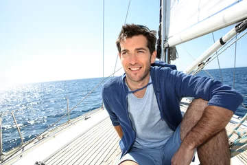 Afwasbaar Fotobehang Zeilen Smiling handsome man on sailboat