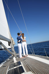Fototapeta premium Fancy couple enjoying sailing on a beautiful sailboat