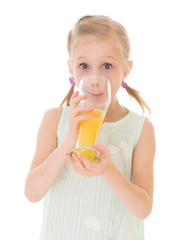 Cute little girl drinks orange juice