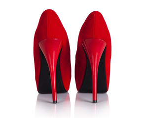 Female red high-heeled shoes over white background.