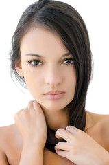 Fototapeta premium Portrait of a beautiful brunette girl.Woman holding her hair.