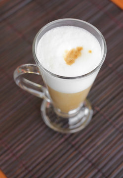 coffee latte with frothy milk in tall glass.