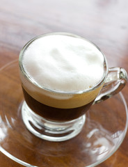 Hot  espresso with milk and foam in cup.