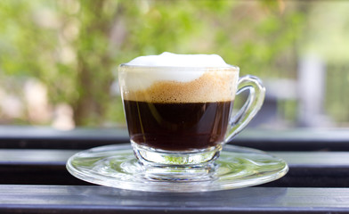 Hot  espresso with milk and foam in cup.