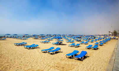 Sunbeds for sunbathing in sunshine, on sand & beach for tourism