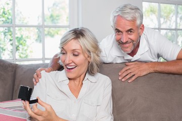 Smiling man surprising woman with a wedding ring