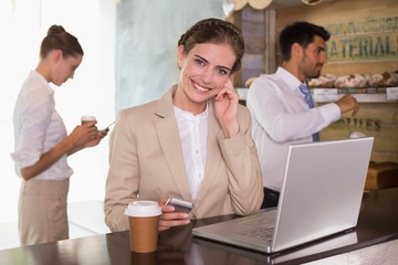 Businesswoman using laptop in office cafeteria