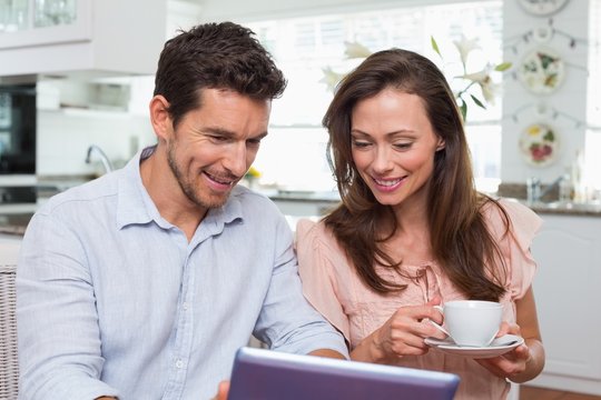 Couple using digital tablet while having coffee