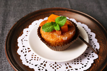 Tasty pumpkin muffin on grey tablecloth