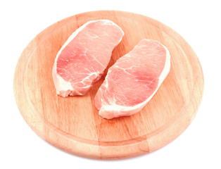 Raw meat steaks on wooden board, isolated on white