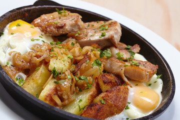 fried meat with potatoes and egg
