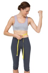 Fototapeta premium Fit woman measuring waist while flexing muscles
