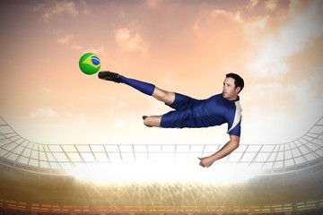 Fototapeta na wymiar Composite image of football player in blue kicking