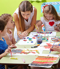 Erzieher und Kinder malen im Kindergarten - obrazy, fototapety, plakaty