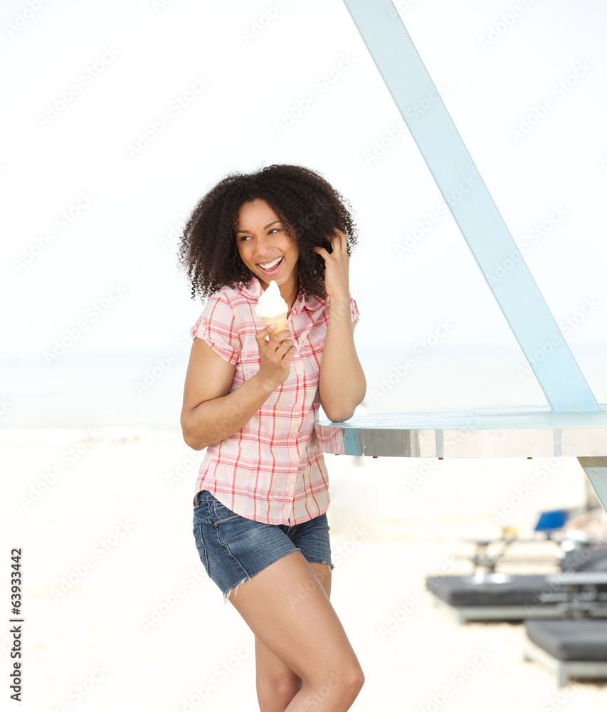 Poster Woman enjoying ice cream at the beach