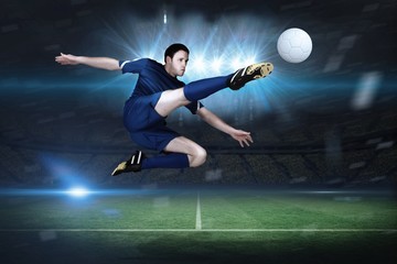 Fototapeta na wymiar Composite image of football player in blue kicking