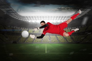 Fototapeta na wymiar Composite image of fit goal keeper jumping up