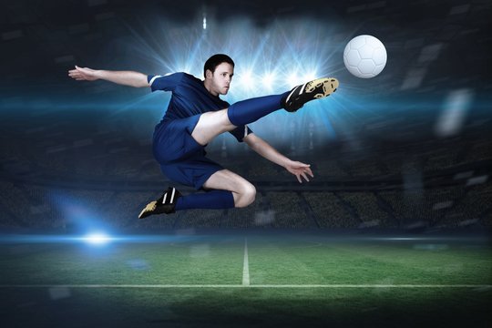 Composite image of football player in blue kicking