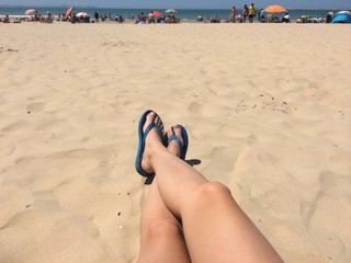 Girl legs and shoes at the beach