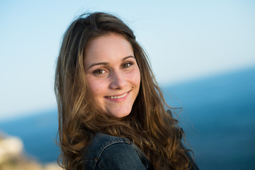 isolated portrait of a cheerful young women by the sea in summer
