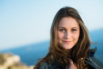 isolated portrait of a cheerful young women by the sea in summer