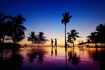 Silhouettes of young couple at scenic sunset