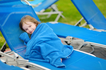 Girl covered with a towel sitting near pool © MNStudio