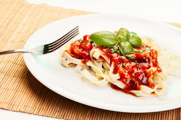 Pasta fettuccine with tomato sauce and basil