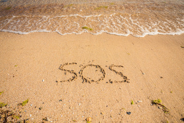 S.O.S written in the sand