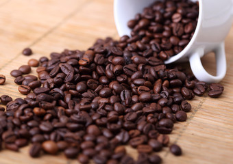 Fototapeta na wymiar Coffee beans on a cup spilled