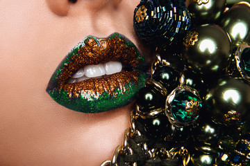 Green and golden lips with jewelry. Make up