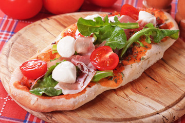 Homemade pizza with prosciutto and mozzarella