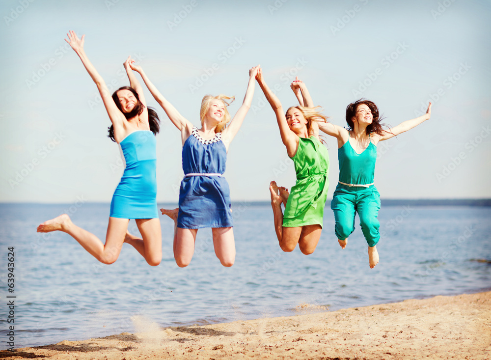 Poster girls jumping on the beach