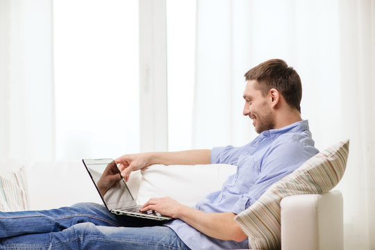 smiling man working with laptop at home