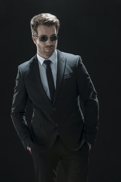 handsome man in black suit on a black background