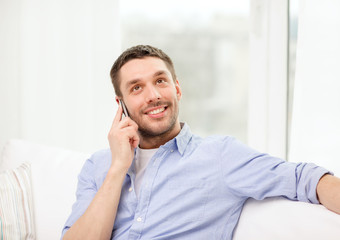 smiling man with smartphone at home