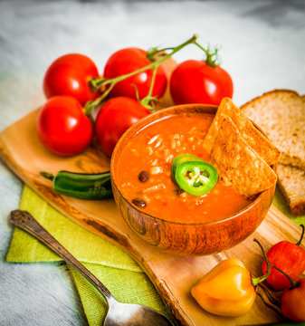 Hot and spicy fresh made Mexican chili soup on rustic background