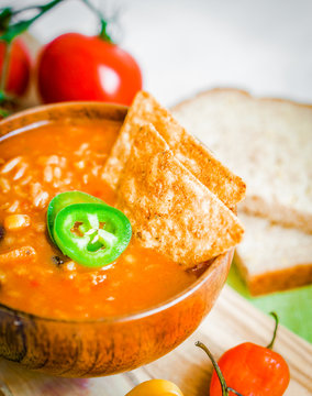 Hot and spicy fresh made Mexican chili soup on rustic background