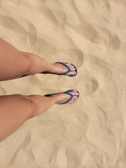 Girl's feet on the sand of the beach