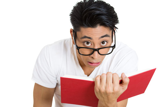 Surprising reading, nerdy funny looking man holds book