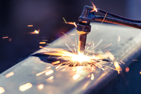 Worker Cutting Steel Pipe Using Metal Torch And Install Roadside