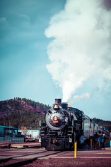 Fototapeta na wymiar Stary parowóz przed niebieskim pochmurne niebo, zabytkowe pociągu