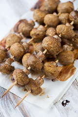 Baked champignons skewers, vertical shot, close-up