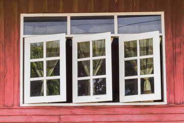 wooden house window with the blinds opened