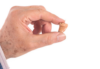 CIC hearing aid between fingers