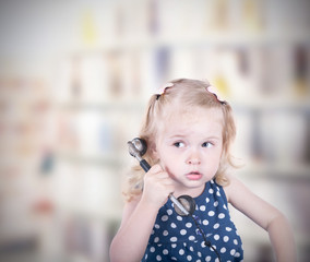 curly-haired little girl with a vintage telephone