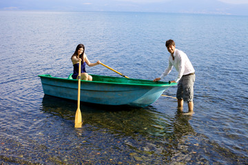 Happy couple in love ready to go boating on lake in vacation