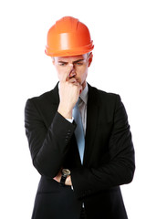 Portrait of a pensive businessman in orange helmet