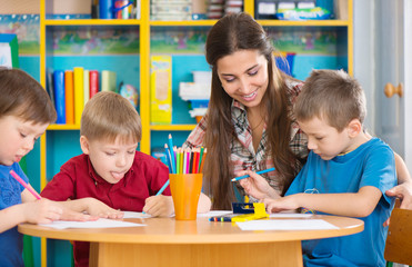 Cute children drawing with teacher at preschool class