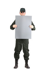 Man in workwear holds paper sheet.
